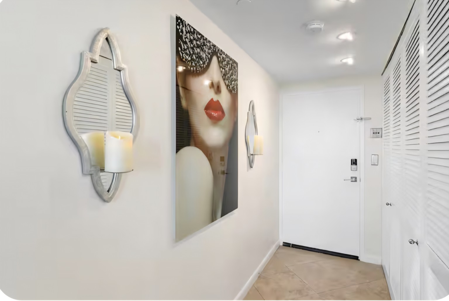 Bright condo entryway with statement artwork, decorative mirrors and clean modern finishes